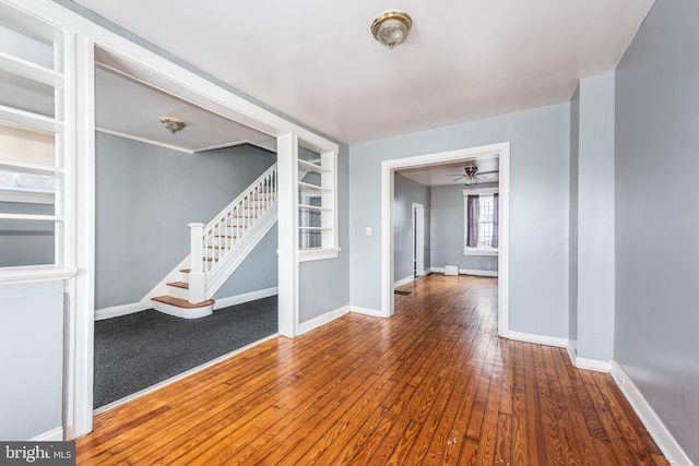 empty room with ceiling fan and hardwood / wood-style flooring