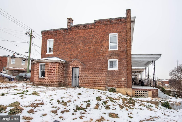 view of snow covered rear of property