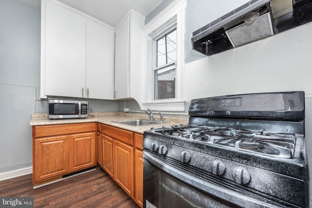 kitchen featuring sink, dark hardwood / wood-style floors, ventilation hood, and gas stove