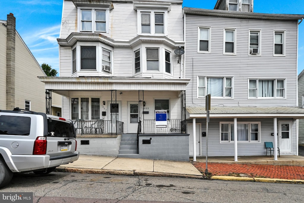 townhome / multi-family property featuring covered porch