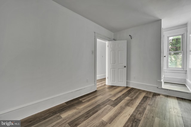 unfurnished room with dark hardwood / wood-style flooring