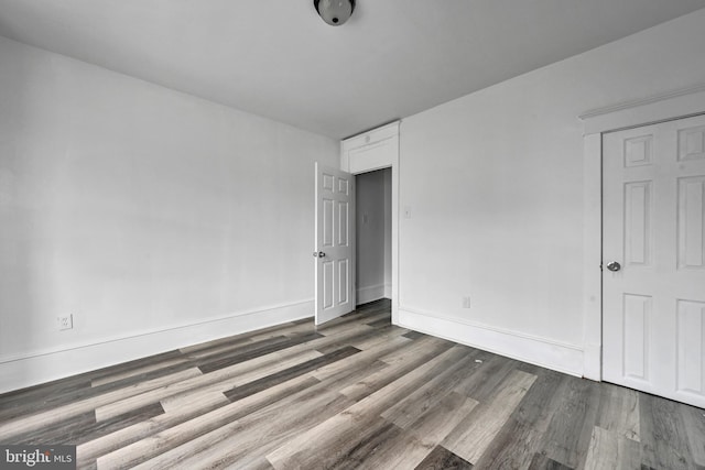 unfurnished room with dark hardwood / wood-style flooring