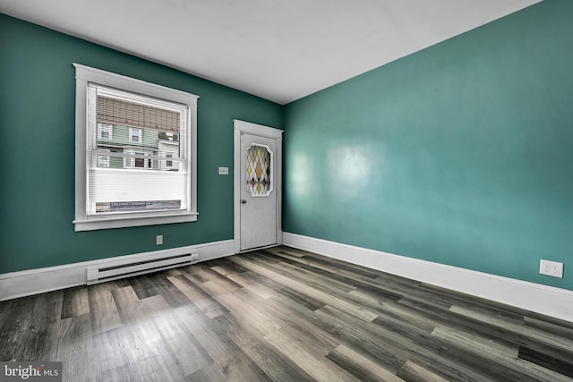 empty room featuring hardwood / wood-style flooring and a baseboard radiator