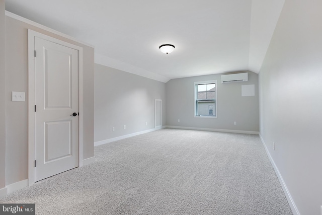 unfurnished room featuring lofted ceiling, a wall mounted AC, and light colored carpet