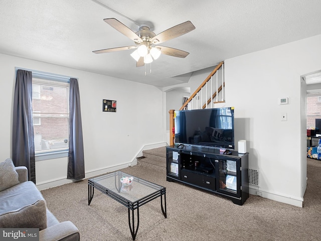 carpeted living room with ceiling fan and a textured ceiling