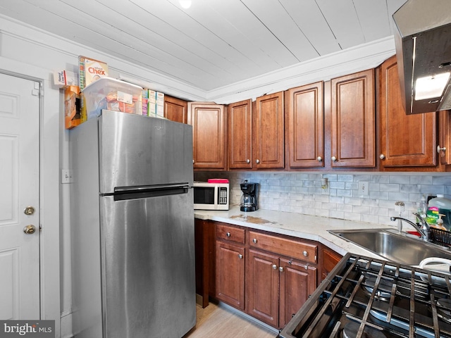 kitchen featuring tasteful backsplash, light hardwood / wood-style floors, sink, appliances with stainless steel finishes, and ornamental molding