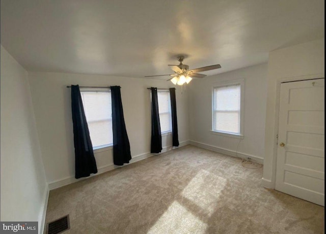 empty room with ceiling fan and light colored carpet