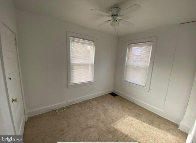 carpeted spare room with ceiling fan