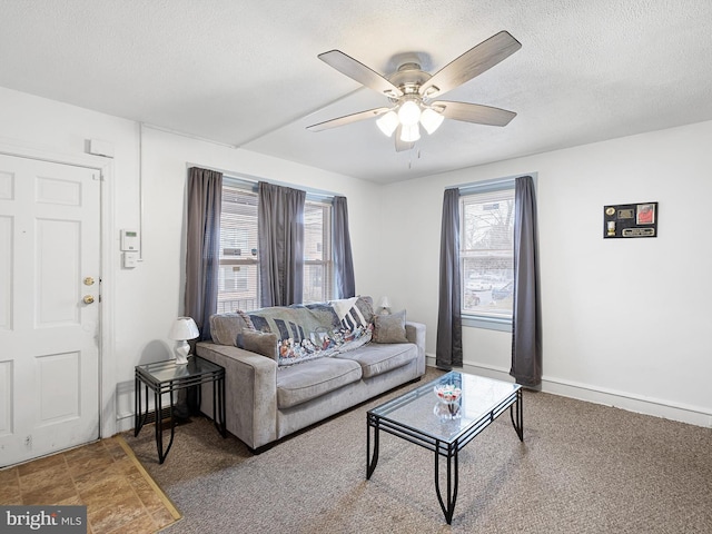 living room featuring ceiling fan, a textured ceiling, and carpet flooring