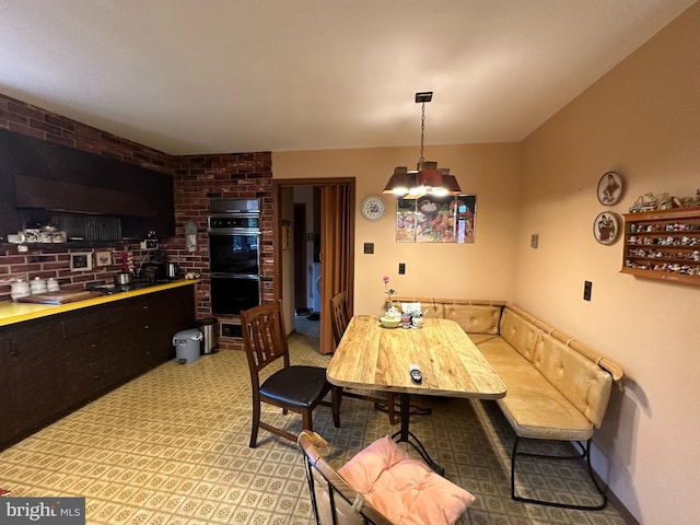 dining room featuring brick wall