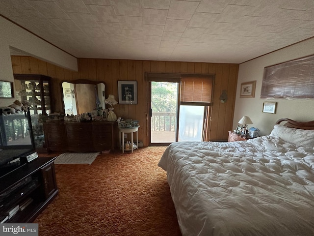 carpeted bedroom featuring access to outside and wood walls