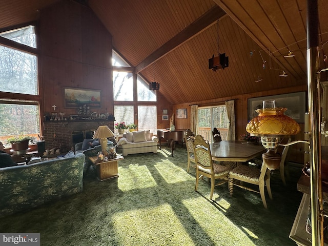 dining space featuring a healthy amount of sunlight, carpet flooring, wooden walls, and high vaulted ceiling