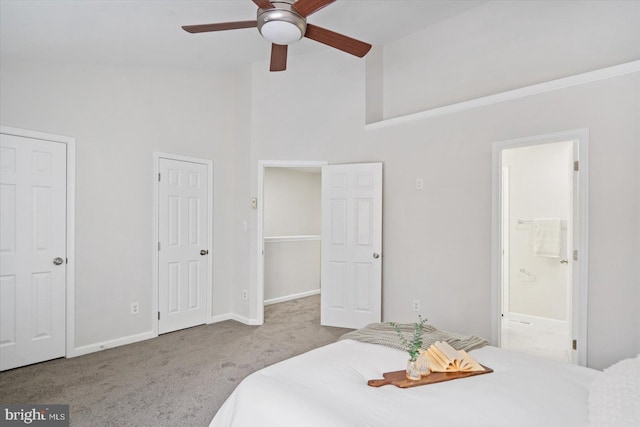 carpeted bedroom with ensuite bath, ceiling fan, and a towering ceiling