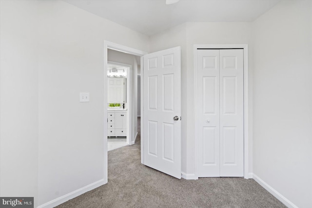 unfurnished bedroom with a closet and light carpet