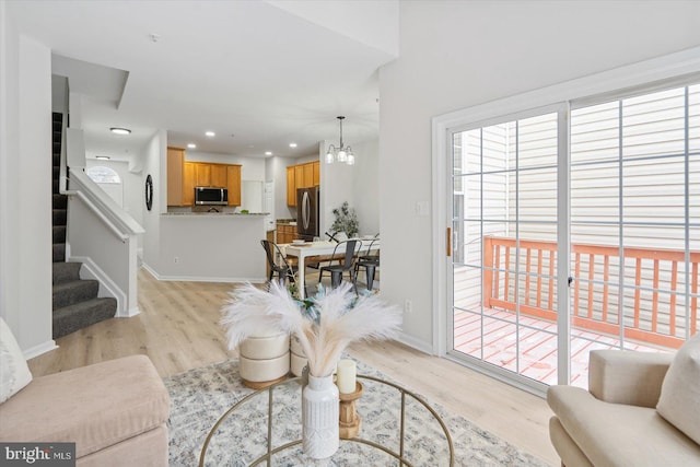 living room with light hardwood / wood-style flooring and an inviting chandelier