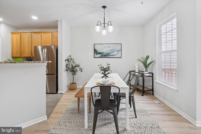 dining area featuring a notable chandelier and light hardwood / wood-style floors