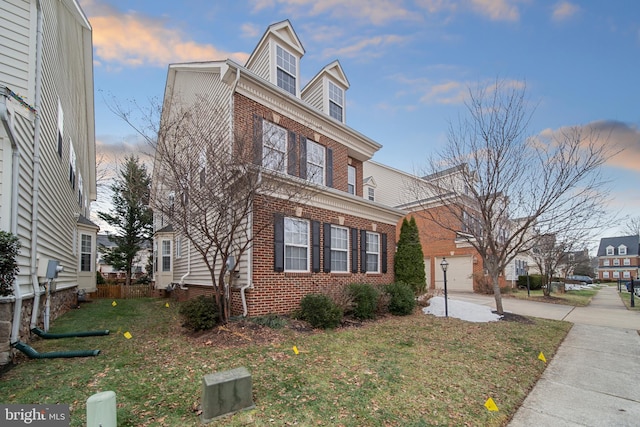 view of front of property with a garage and a lawn