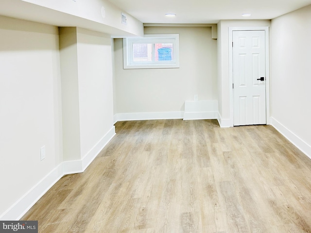 basement with light hardwood / wood-style flooring