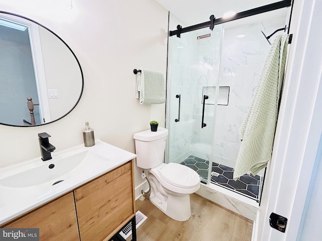 bathroom featuring toilet, vanity, a shower with door, and hardwood / wood-style floors