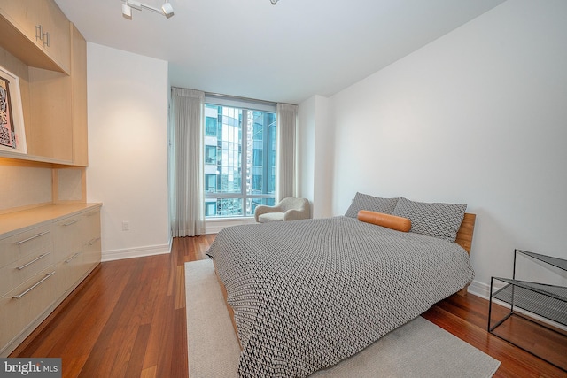 bedroom with dark wood-type flooring