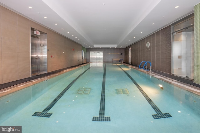 view of swimming pool featuring elevator