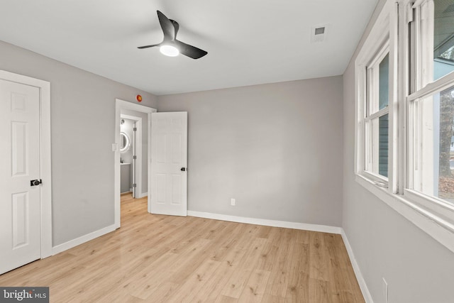 unfurnished bedroom featuring ceiling fan, multiple windows, and light hardwood / wood-style floors