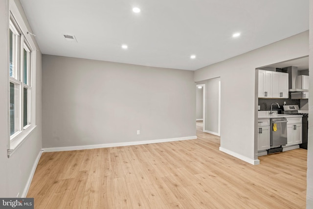 kitchen featuring white cabinets, appliances with stainless steel finishes, plenty of natural light, and light hardwood / wood-style floors