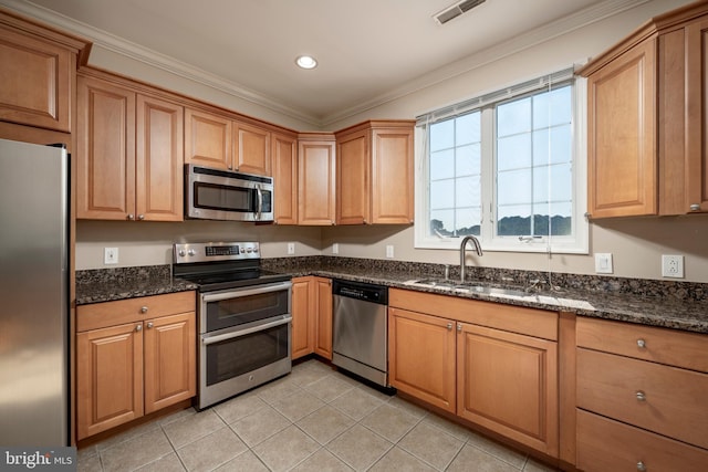 kitchen featuring light tile patterned floors, stainless steel appliances, dark stone counters, and sink