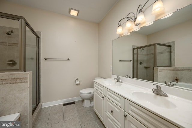 bathroom featuring walk in shower, vanity, tile patterned flooring, and toilet