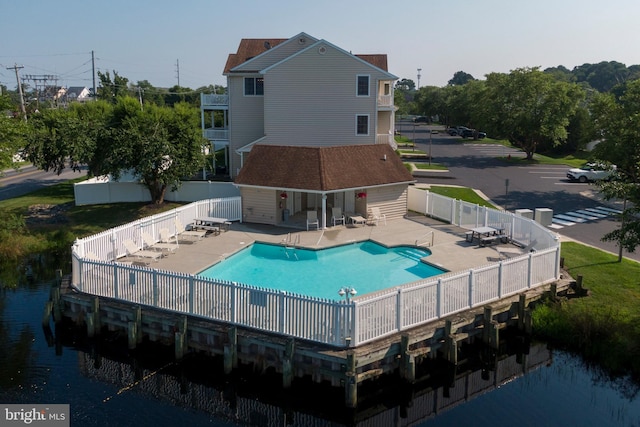 view of pool with a water view and a patio area