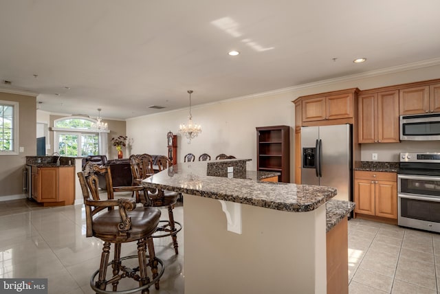 kitchen featuring a notable chandelier, a kitchen island, pendant lighting, light tile patterned flooring, and stainless steel appliances