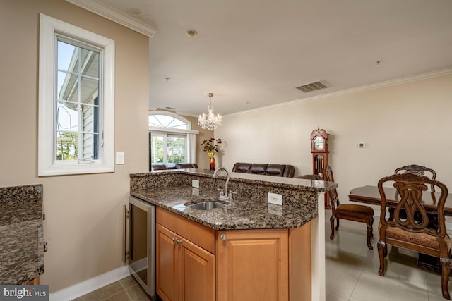 kitchen with sink, kitchen peninsula, wine cooler, and dark stone countertops