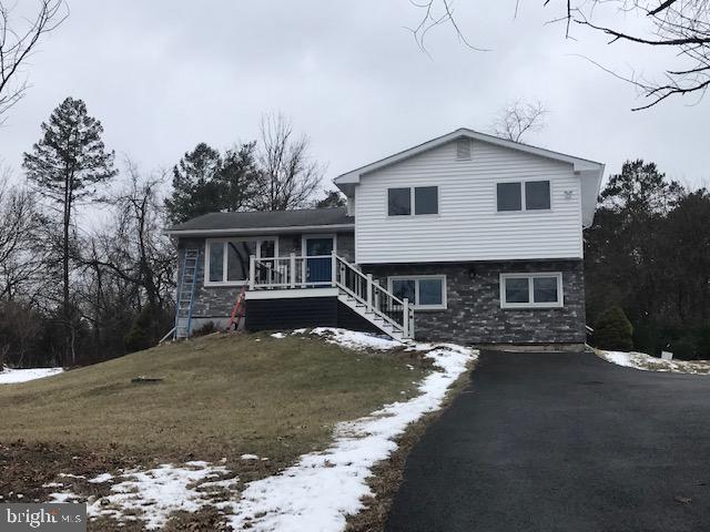 tri-level home featuring covered porch and a lawn