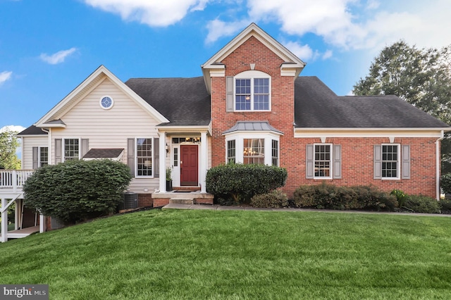 view of property featuring a front yard and central AC