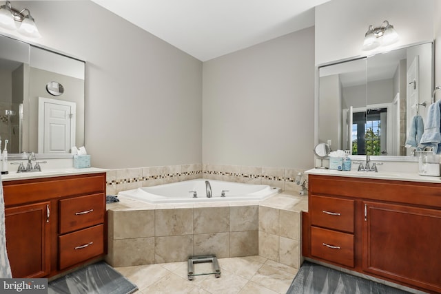 bathroom with vanity, tile patterned floors, and tiled tub