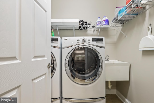 laundry area with washer and dryer, tile patterned flooring, and sink