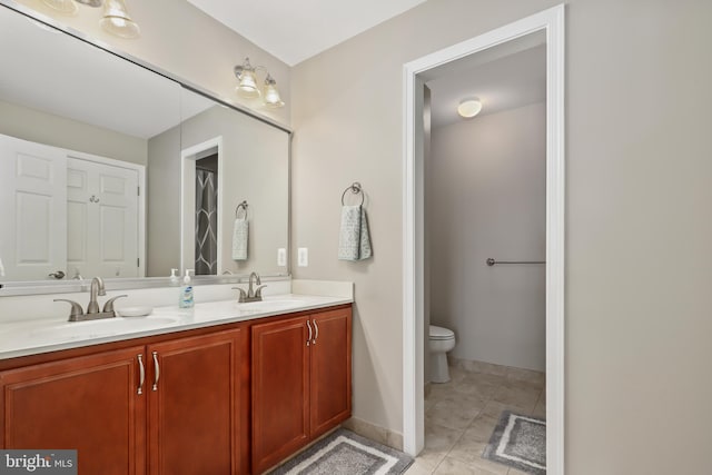 bathroom with toilet, tile patterned floors, and vanity