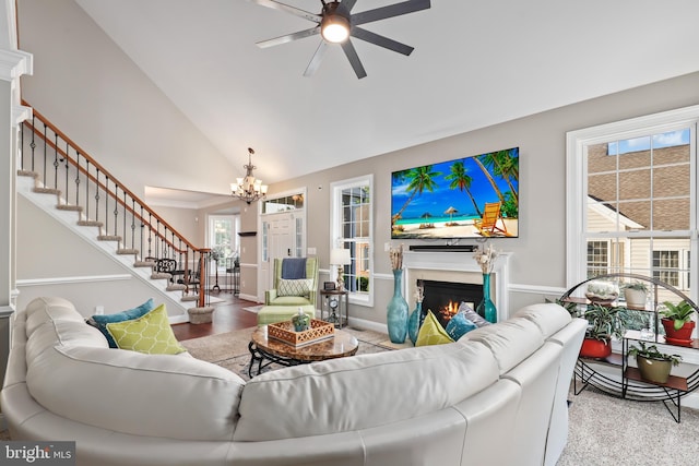 living room with vaulted ceiling and ceiling fan with notable chandelier