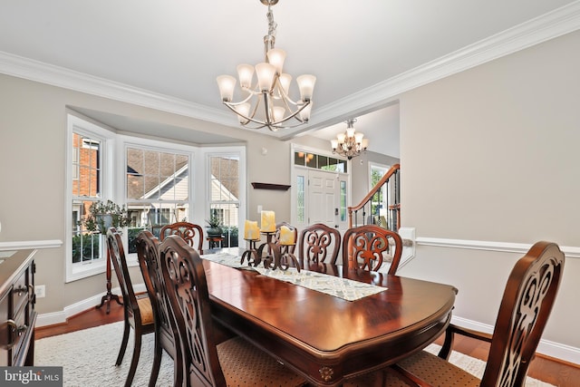 dining space featuring an inviting chandelier, crown molding, and hardwood / wood-style floors