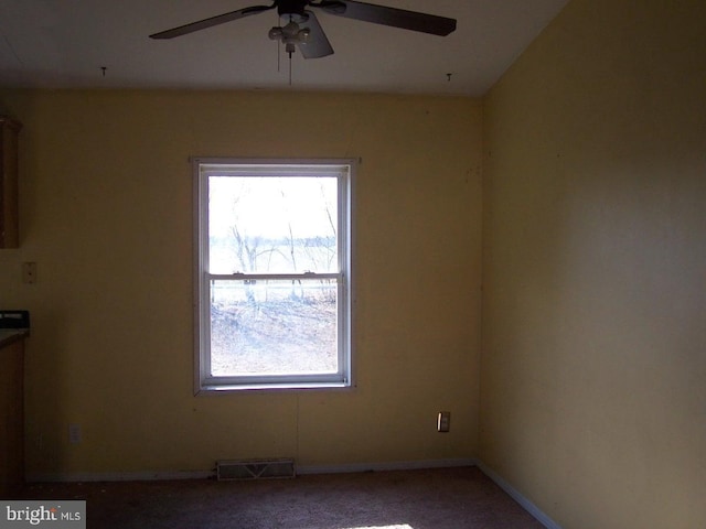 carpeted spare room featuring ceiling fan