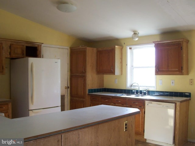 kitchen featuring vaulted ceiling, sink, and white appliances