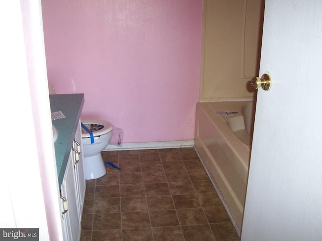 bathroom featuring toilet, a bathing tub, and vanity