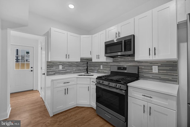 kitchen with appliances with stainless steel finishes, white cabinets, and sink