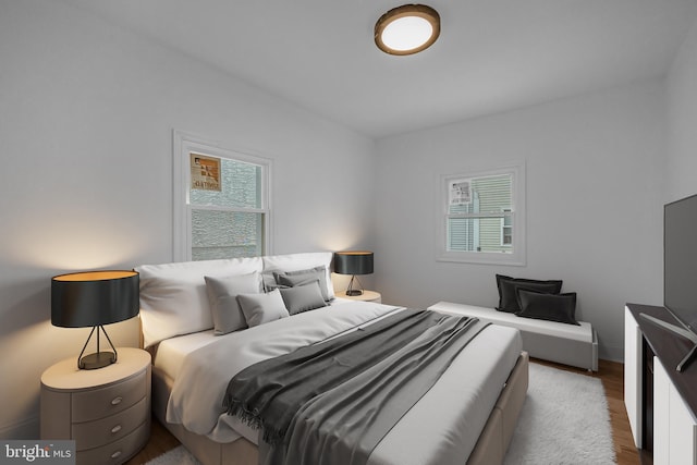 bedroom featuring multiple windows and hardwood / wood-style flooring