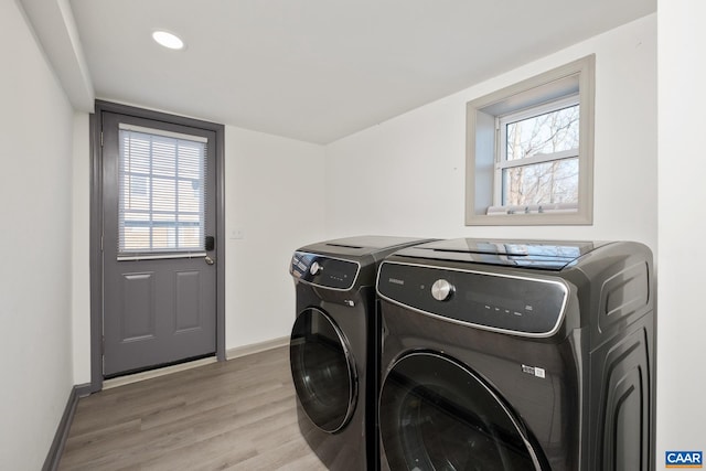 washroom with separate washer and dryer and light wood-type flooring