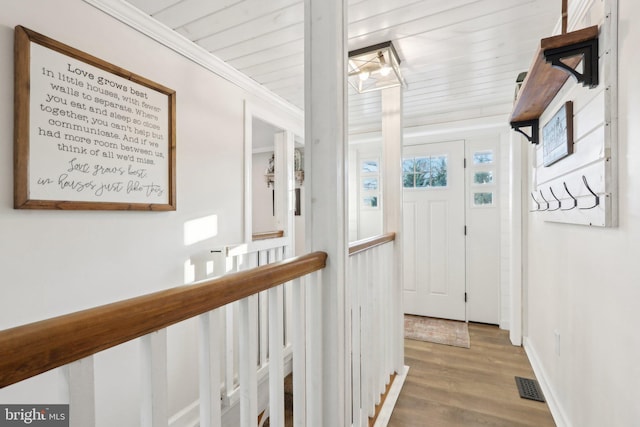 hallway featuring ornamental molding and hardwood / wood-style flooring