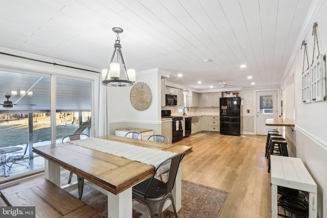 dining space with wood ceiling, sink, ornamental molding, light wood-type flooring, and ceiling fan