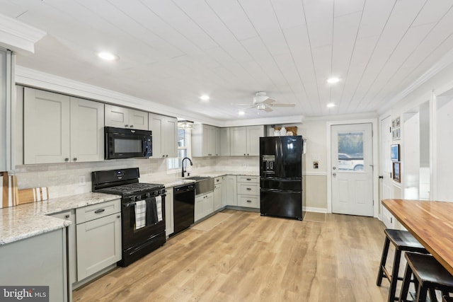 kitchen featuring black appliances, backsplash, gray cabinets, ceiling fan, and light hardwood / wood-style flooring