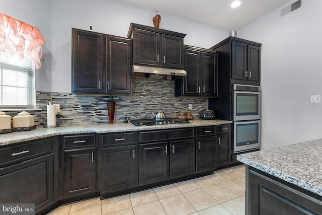 kitchen with gas stovetop, light tile patterned floors, backsplash, and double oven