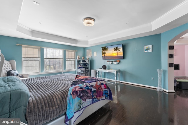 bedroom featuring dark hardwood / wood-style flooring, crown molding, and a raised ceiling